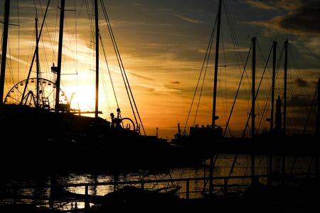 spectacular sunset in the port of Genoa and in the background the Ferris wheel