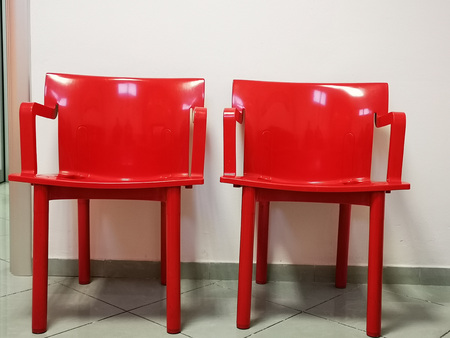 red modern chairs in waiting room of an Italian office