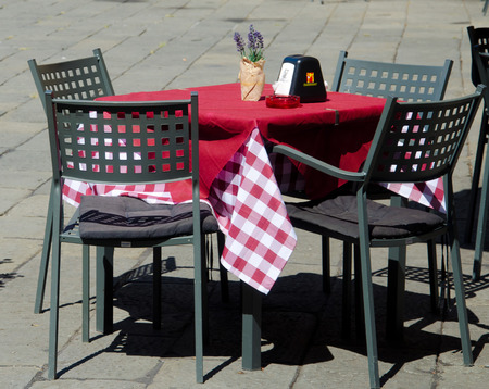 small table of an Italian restaurant with chairs and its checkered tablecloth typical of old taverns
