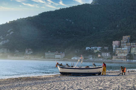fishermen in boats along the Italian coasts of Liguria while doing their jobの写真素材