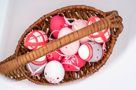 wicker basket with colored easter eggs, on a white background in the period of easter 2023の写真素材