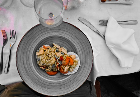 white plate of seafood spaghetti pasta with mussels and clams from an Italian restaurant in Liguria. the Italian kitchenの写真素材