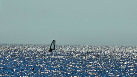 Windsurfing is a sporting activity as well as a sailing specialty which consists of moving on the water on a board thanks mainly to the propulsive action determined by the windの写真素材