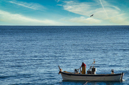 Fishing boat in the sea on a background of blue sky.