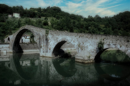 Old stone bridge over the river in Tuscany, Italy.の写真素材
