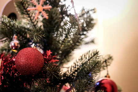 Christmas tree with red balls and snowflakes on a blurred backgroundの写真素材