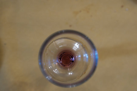 glass wine glass seen from above with a residual bottom of red wine in an Italian barの写真素材