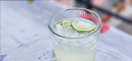 a gin and tonic in a glass, an alcoholic summer cocktail for evenings by the sea