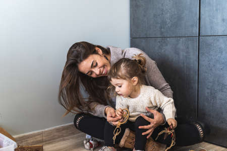 Young woman laughing with her daughter in the living room