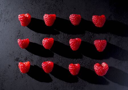 Red raspberries on black plateの写真素材