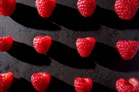 Red raspberries on black plateの写真素材
