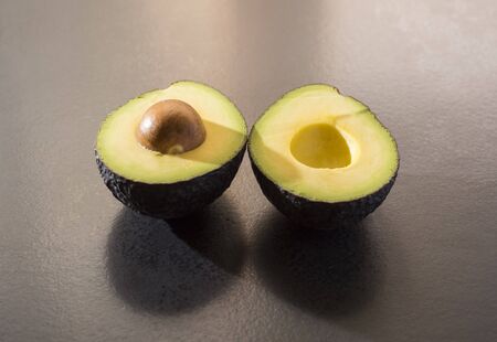 Avocado cut on black plateの写真素材