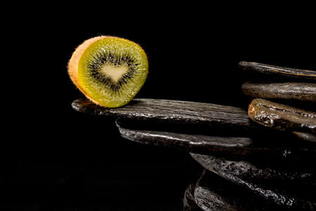 Creative pictures of fresh kiwis on slate and black background