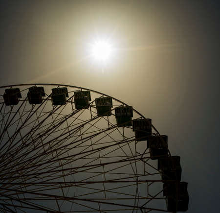 The typical fairground ferris wheel stopped in an amusement park on a hot summer dayの写真素材