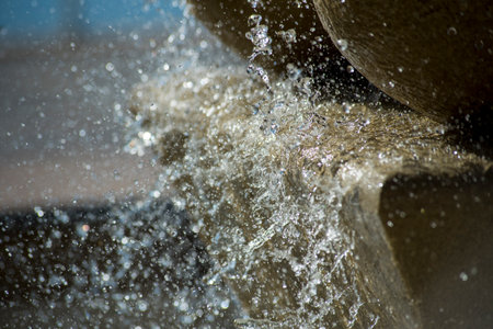 Water splashes in the air on a dark background. Shallow depth of fieldの写真素材