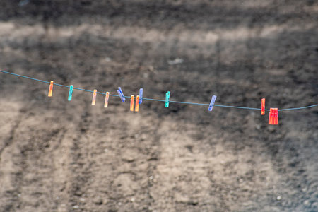 Clothespins on a rope on a background of the soil.