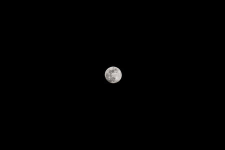 Full moon in the night sky. Isolated on black background.の写真素材