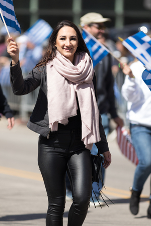Chicago, Illinois, USA - April 29, 2018 Young greek woman waving the greek flag during the  Greek Independence  Day Paradeのeditorial素材