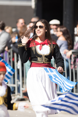 Chicago, Illinois, USA - April 29, 2018  Greek woman wearing traditional clothing waving the greek flag at the Greek Independence  Day Paradeのeditorial素材