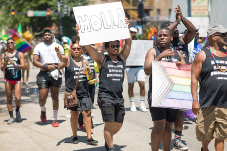 Chicago, Illinois, USA - June 24, 2018 People wearing shirts that say, black men loving black men is a revolutionary act. Joseph Beam  celebrating during the LGBTQ Pride Parade in Chicagoのeditorial素材