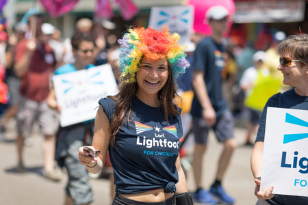 Chicago, Illinois, USA - June 24, 2018 Young woman wearing a wig with the colors of the rainbow and a shirt that promotes Lori Lightfoot for chicago during the LGBTQ Pride Parade in Chicagoのeditorial素材