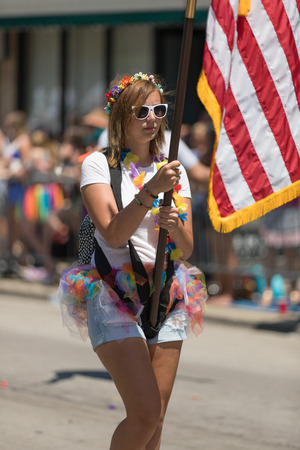 Chicago, Illinois, USA - June 24, 2018 Young woman carries the american flag during the LGBTQ Pride Parade in Chicagoのeditorial素材