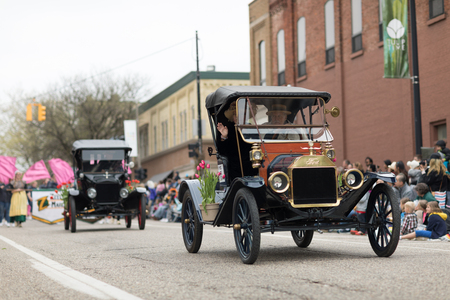 Holland, Michigan, USA - May 12, 2018 Ford Model T, with tulip flowers, driven by men wearing retro clothing, drive down the road at the Muziek Parade, during the Tulip Time Festivalのeditorial素材