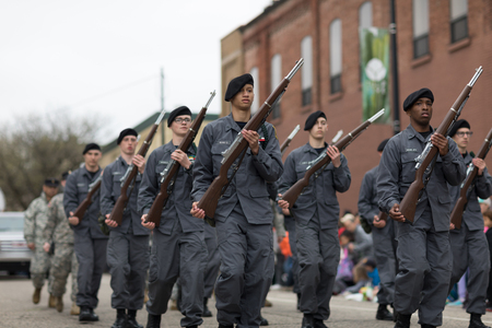 Holland, Michigan, USA - May 12, 2018 Members of the Michigan Youth ChalleNGe Academy marching down the road wearing military like uniform and holding rifles at the Muziek Parade, during the Tulip Time Festivalのeditorial素材