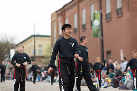 Holland, Michigan, USA - May 12, 2018 Young asian man wearing martial arts outfit walking down the road at the Muziek Parade, during the Tulip Time Festivalのeditorial素材