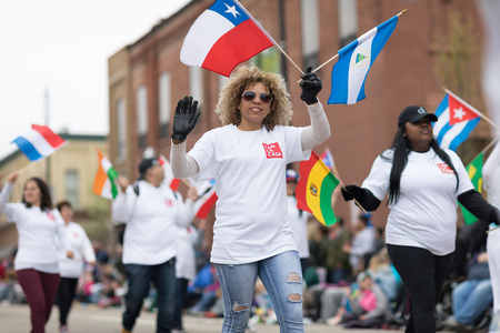 Holland, Michigan, USA - May 12, 2018 Members of La Casa De Mi Padre Church carry flag from diferent nations at the Muziek Parade, during the Tulip Time Festivalのeditorial素材