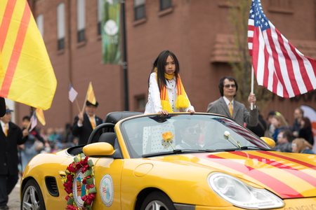 Holland, Michigan, USA - May 12, 2018 Members of Michigan Vietnamese American Community wearing traditional clothing and waving american and vietnamese flags at the Muziek Parade, during the Tulip Time Festivalのeditorial素材