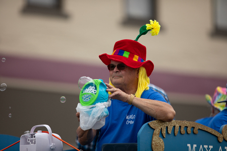 Peru, Indiana, USA - July 21, 2018 Man wearing a hat with a flower making bubbles with a machine at the Circus City Festival Paradeのeditorial素材