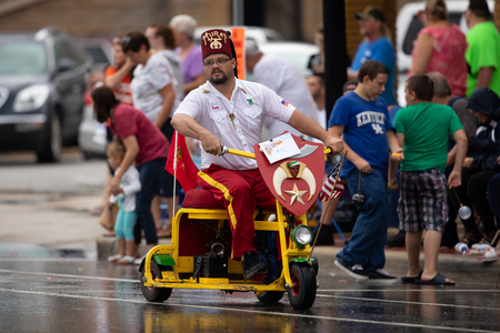 Peru, Indiana, USA - July 21, 2018 Man riding a scooter  under the rain at the Circus City Festival Paradeのeditorial素材