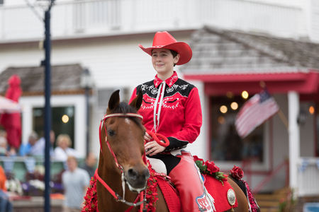 Frankenmuth, Michigan, USA - June 10, 2018 Women wearing red outfits from the Harmony Acres Arabians ridding horses down the road at the Bavarian Festival Parade.のeditorial素材