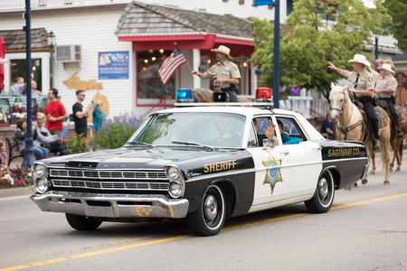 Frankenmuth, Michigan, USA - June 10, 2018 An old ford classic police car going down the road at the Bavarian Festival Parade.のeditorial素材