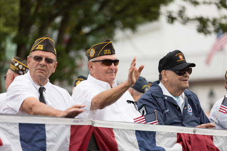 Frankenmuth, Michigan, USA - June 10, 2018 Military Veterans from Frankenmuth riding on top of a trailer holding american flags at the Bavarian Festival Parade.のeditorial素材