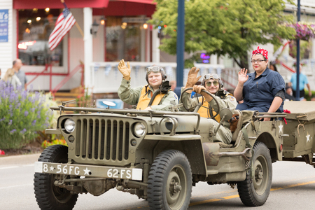 Frankenmuth, Michigan, USA - June 10, 2018 Men and women riding world war two military jeeps wearing pilot outfits at the Bavarian Festival Parade.のeditorial素材