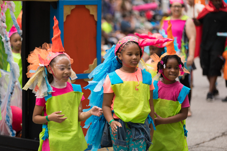 Cleveland, Ohio, USA - June 9, 2018 Afro american children wearing colorful outfits playing with a balloon At the abstract art festival Parade The Circleのeditorial素材