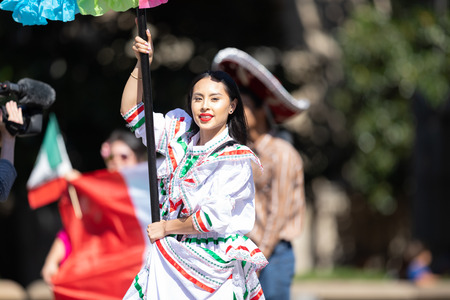 Washington, D.C., USA - September 29, 2018: The Fiesta DC Parade, woman wearing traditional clothing from Mexico carrying a bannerのeditorial素材