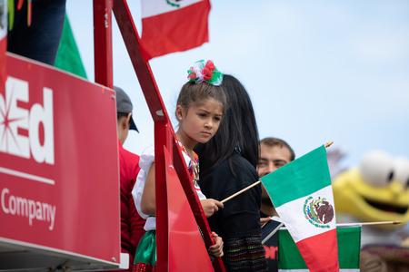 Chicago, Illinois , USA - September 9, 2018 The 26th Street Mexican Independence Parade, mexican girl wearing traditional clothing on top of a float waving a mexican flagのeditorial素材