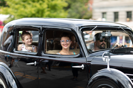 Auburn, Indiana, USA - September 9, 2018 The Auburn Cord Duesenberg Festival, a family driving in An Auburn classic car driving down the street during the paradeのeditorial素材