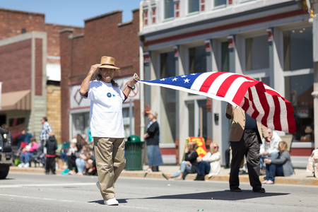 Orleans, Indiana, USA - April 28, 2018: The Orleans DogWood Festival and Parade, two men carrying the american flag during the paradeのeditorial素材