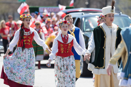 Chicago, Illinois, USA - May 5, 2018: The Polish Constitution Day Parade, Polish men and women wearing traditional clothing members of the Polonia Polish Folk Song and Dance Ensemble singing while walking down the street during the paradeのeditorial素材