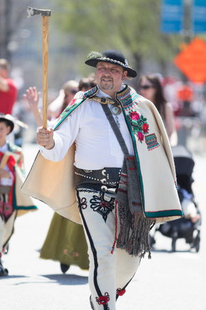 Chicago, Illinois, USA - May 5, 2018: The Polish Constitution Day Parade, Polish man wearing traditional clothing,  goral dress hat and axe during the paradeのeditorial素材
