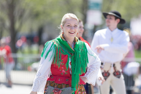 Chicago, Illinois, USA - May 5, 2018: The Polish Constitution Day Parade, Polish woman wearing traditional clothing walking down the street during the paradeのeditorial素材