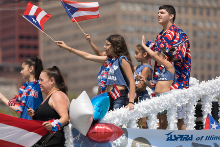 Chicago, Illinois, USA - June 16, 2018: The Puerto Rican Day Parade, Puerto Rican people on top of a...