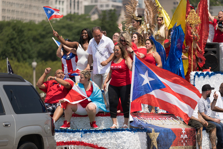 Chicago, Illinois, USA - June 16, 2018: The Puerto Rican Day Parade, Puerto Rican people on top of a float celebrating waving puerto rican flags during the paradeのeditorial素材