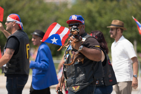 Chicago, Illinois, USA - June 16, 2018: The Puerto Rican Day Parade, Man dress up as a biker holds his pet chihuahua with a biker outfit for the cameraのeditorial素材