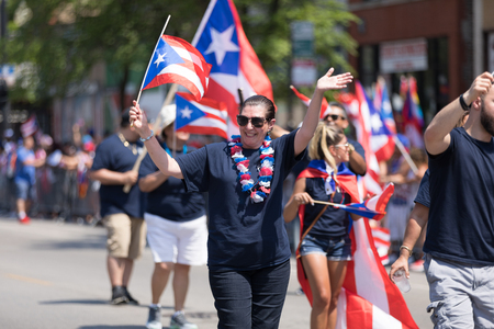 Chicago, Illinois, USA - June 16, 2018: The Puerto Rican People's Parade, Puerto Rican people carrying puerto rican flags celebrating during the paradeのeditorial素材