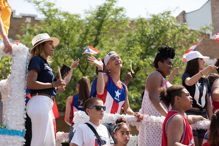 Chicago, Illinois, USA - June 16, 2018: The Puerto Rican People's Parade, Puerto Rican people on top of a float celebrating waving puerto rican flags during the paradeのeditorial素材